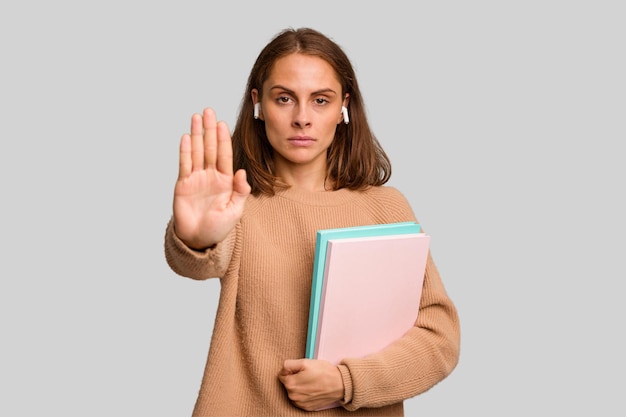 De pie con la mano extendida que muestra la señal de alto que le impide