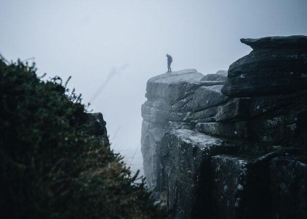 Foto de pie solo en una montaña de niebla