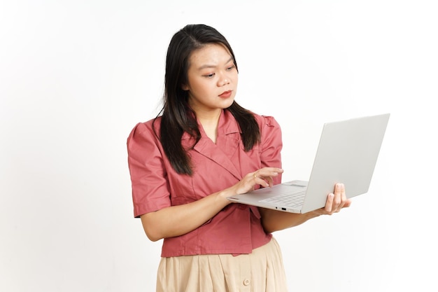 De pie y trabajando con la computadora portátil de la hermosa mujer asiática aislada sobre fondo blanco