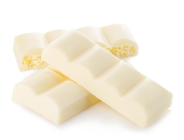 Foto pieces de chocolate branco em close-up isolados em um fundo branco