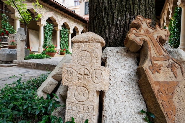 La piedra antigua cruza en el jardín un edificio con un peristilo