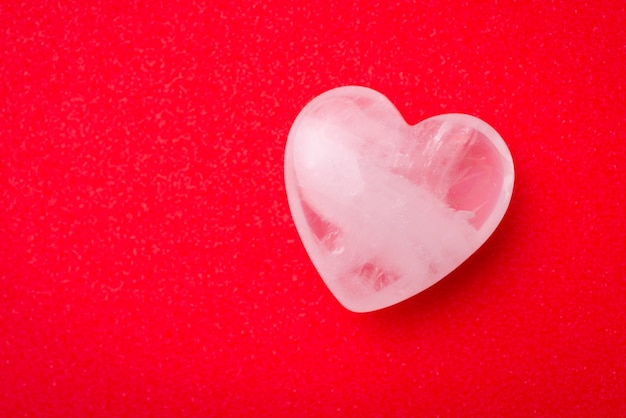 Piedra blanca transparente en forma de corazón en mesa roja