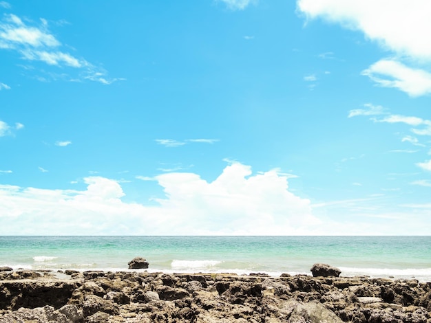 Piedra en la costa con mar azul y cielo azul