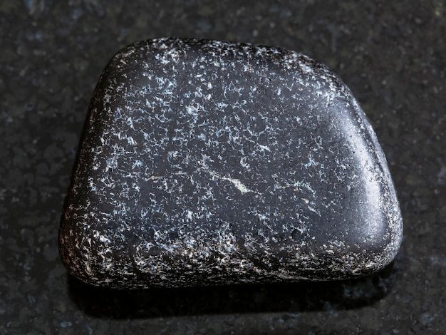Piedra cromita pulida sobre fondo oscuro