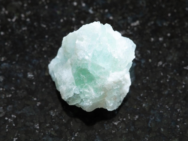 Piedra de fluorita cruda sobre fondo oscuro