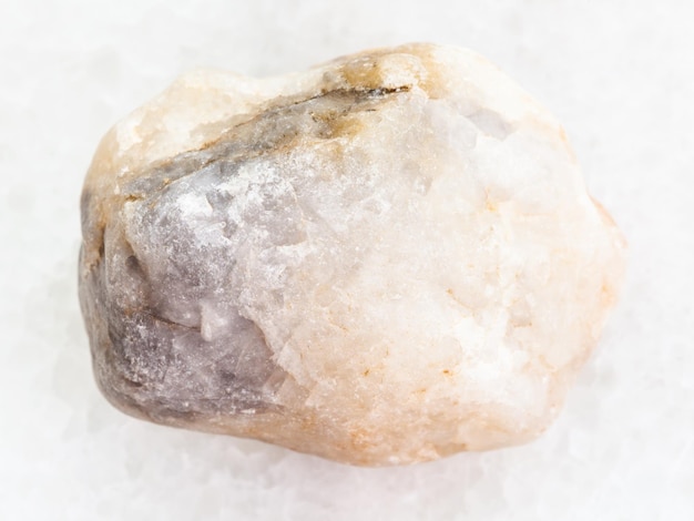 Piedra de mármol en bruto sobre fondo de mármol blanco