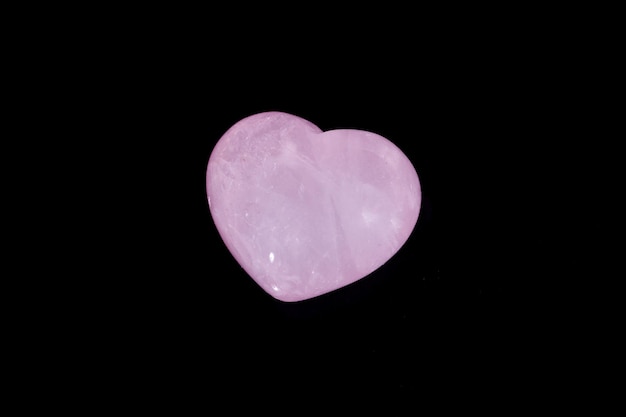 Piedra mineral macro Corazón cuarzo rosa sobre fondo negro