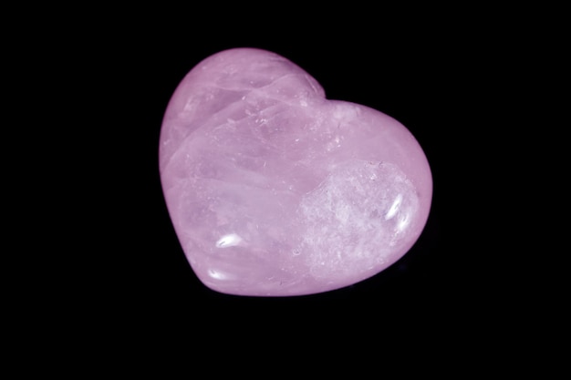 Piedra mineral macro Corazón cuarzo rosa sobre fondo negro