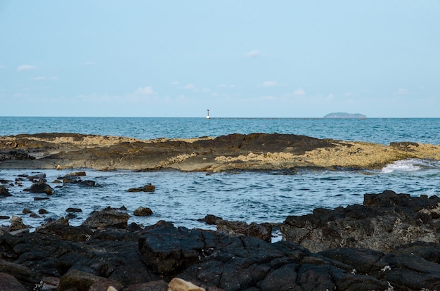 Piedra negra con mar azul.