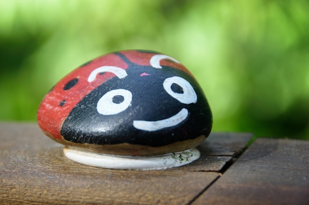 Piedra pintada con forma y colores de mariquita.