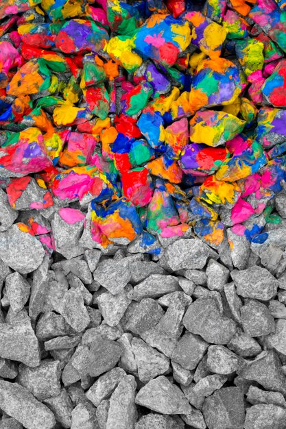 Foto piedras coloreadas con tinta de un color diferente en una mitad, la segunda mitad - piedras grises monocromáticas. de cerca