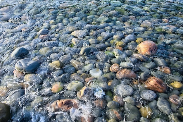 piedras de colores alrededor del mar / textura piedras redondeadas húmedas, fondo de verano multicolor húmedo