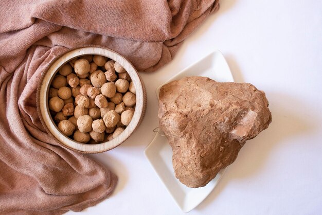 Piedras comestibles de arcilla de caramelo sobre un plato redondo de madera y piedra de arcilla marrón sobre un fondo blanco