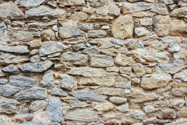 Piedras de diferentes formas y tamaños están integradas en la pared.