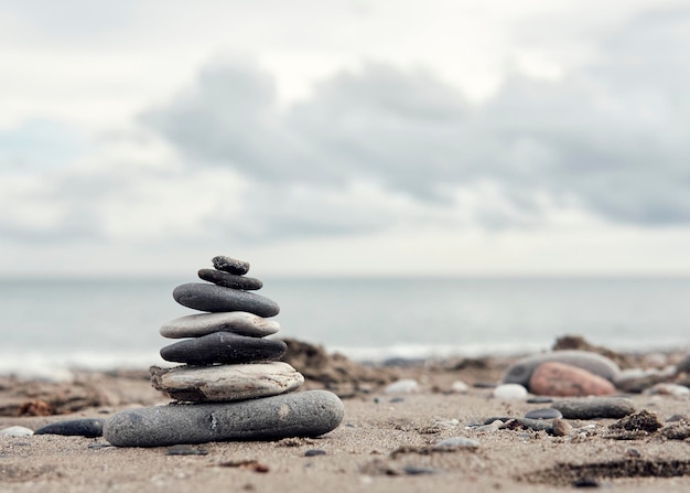 Piedras de equilibrio zen en una playa nublada