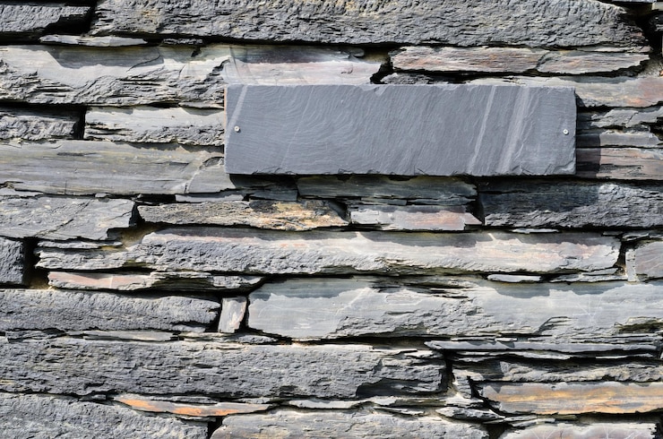 Foto piedras de esquisto en una casa apiladas a una pared