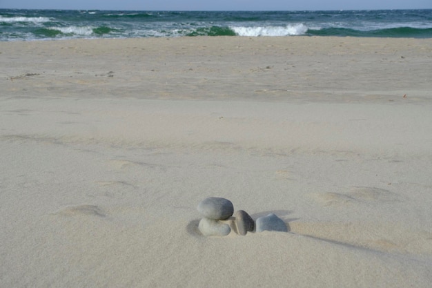 Las piedras están cubiertas con arena de cuarzo en la playa durante el fuerte viento