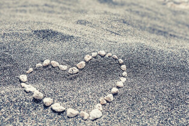 Piedras en forma de corazón en la arena. Enfoque selectivo.