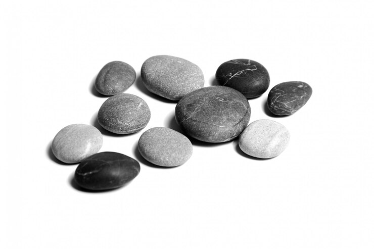Piedras, guijarros de mar aislados en superficie blanca