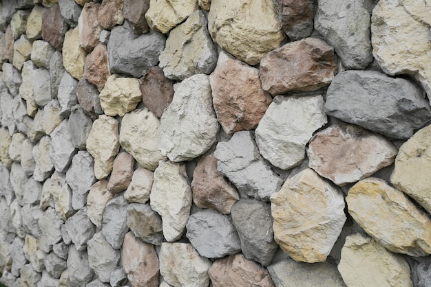 Piedras y guijarros en pared gris.