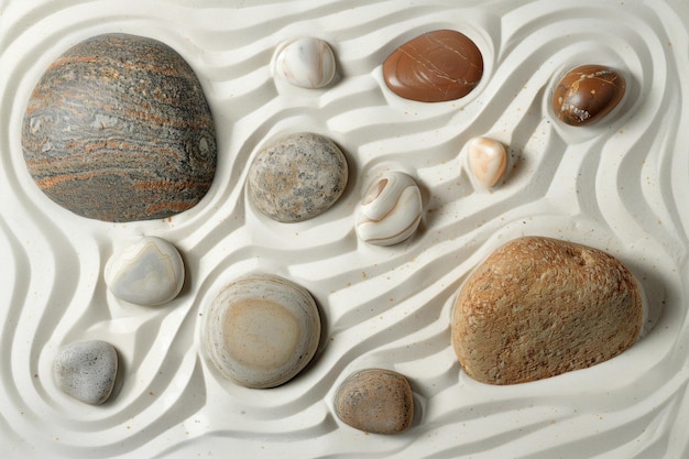 Piedras de jardín Zen en arena blanca con patrón