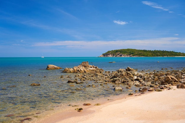 Piedras en el mar en una orilla arenosa Perfecta playa desierta