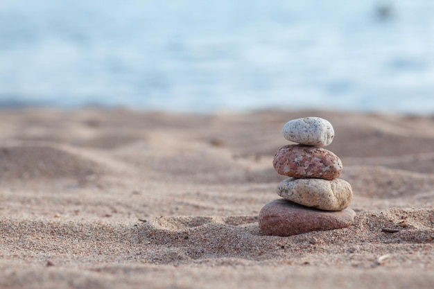 Las piedras redondas se encuentran una encima de la otra en una columna a orillas del mar en un día soleado de verano