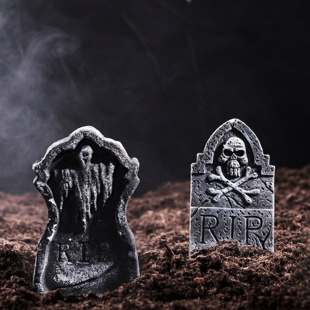 Foto piedras sepulcrales con cráneo y huesos en el cementerio nocturno