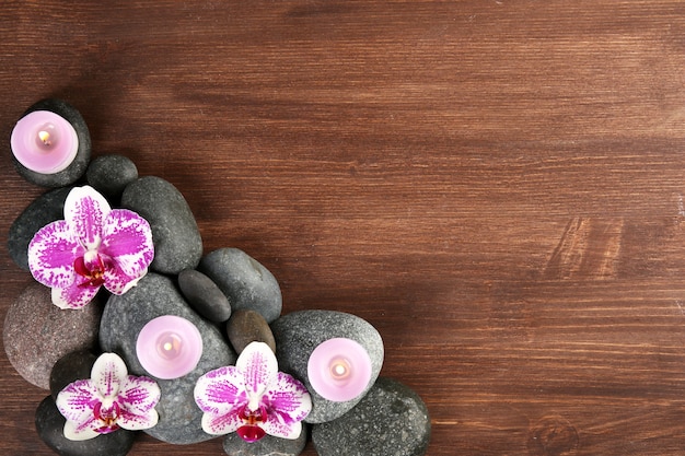 Foto piedras de spa y orquídea en madera