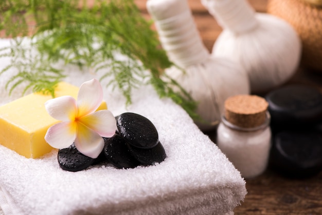 Piedras de spa con toalla y plumeria.