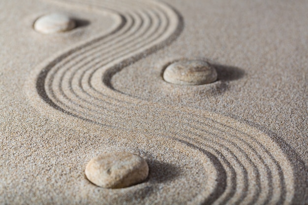 Piedras zen en la arena. Fondo gris