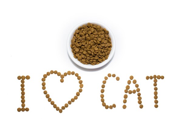 Pienso para perros y gatos en recipiente blanco. Corazón de la comida. Inscripción me encantan los gatos. Estudio de fondo blanco. Foto de alta calidad