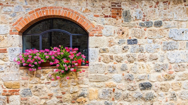 Pienza, región de Toscana, Italia. Ventana vieja con flores