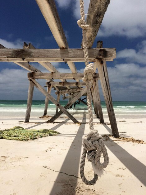 Foto pier abandonado na praia contra o céu nublado