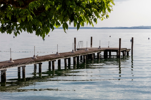 Píer no lago de garda em um dia ensolarado com algumas nuvens