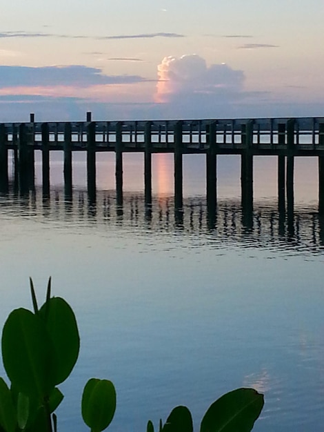 Foto pier über dem fluss gegen den himmel bei sonnenuntergang