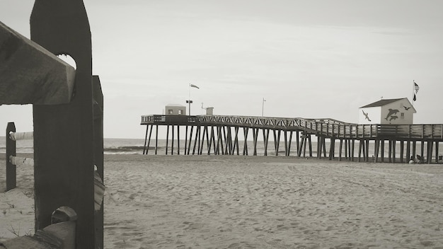 Foto pier über sand am strand gegen den himmel