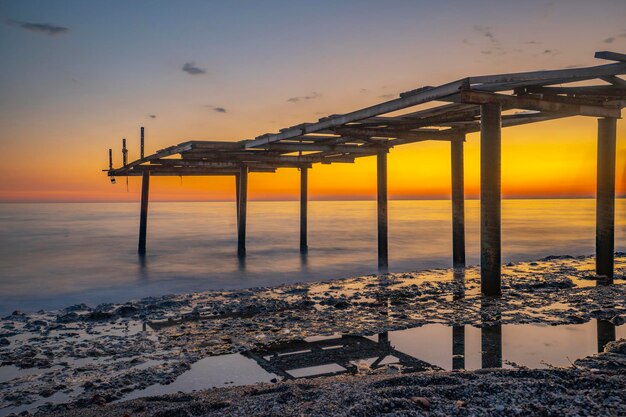 Pier und Meer treffen sich mit Sonnenuntergang