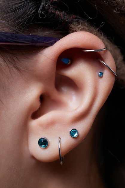 Piercings an einer Ohrmuschel und Helix-Piercings aus nächster Nähe