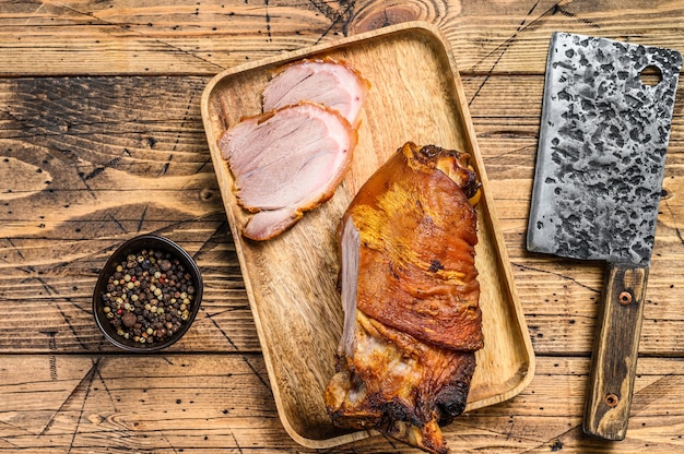 Foto pierna de cerdo al horno en rodajas sobre una tabla para cortar