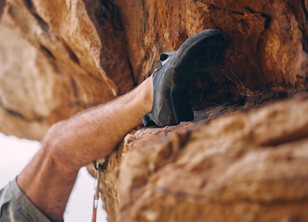 Pierna de hombre escalando montaña rocosa o piedra para hacer ejercicio, aventura o ejercicio Boulder deporte y fitness de escalador masculino entrenando fuera del campo o naturaleza montañismo senderismo o escalada