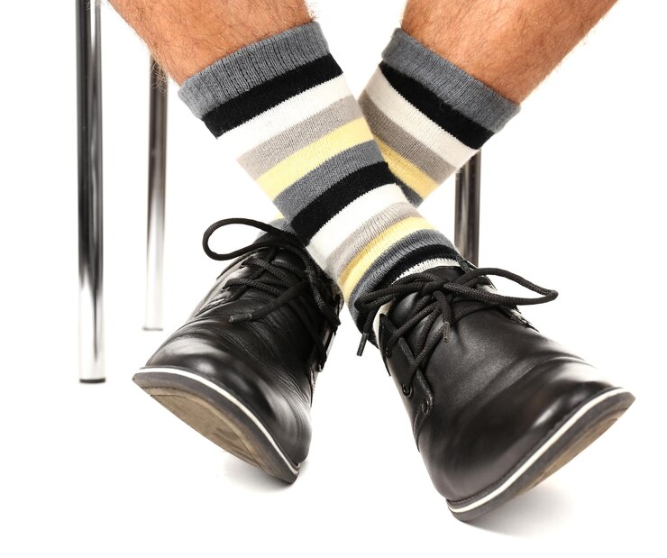 Foto pierna de hombre en traje y calcetines coloridos aislados en blanco