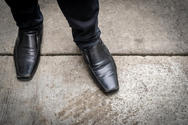 Foto pierna de pie con los pies de cuero negro clásico