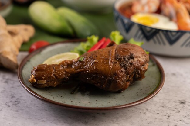 Pierna de pollo asada con chile de lechuga y lima en un plato