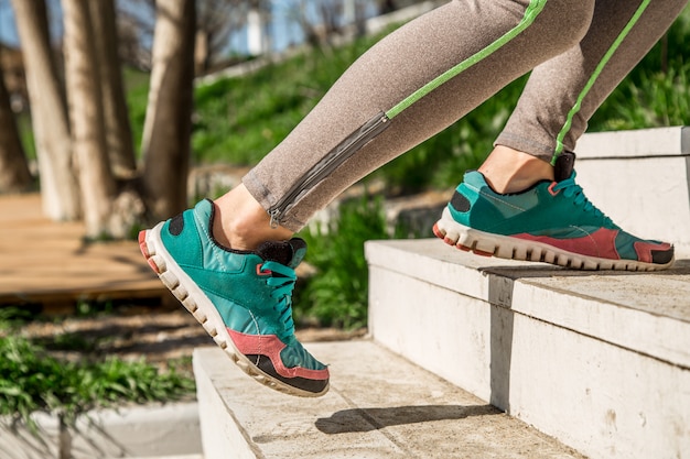 Las piernas atléticas femeninas suben las escaleras