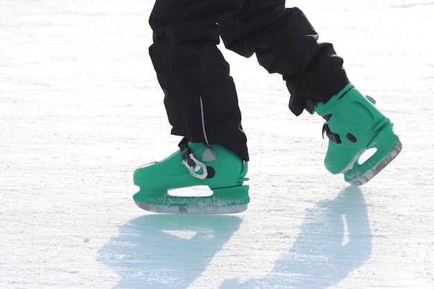 Piernas en azul patinando en la pista de hielo. Deporte y entretenimiento. Descanso y vacaciones de invierno.