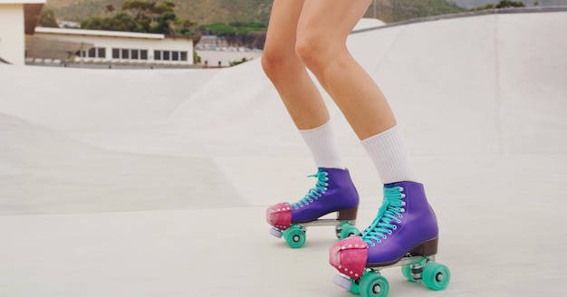 Piernas de botas y mujer en patines para entrenamiento físico y deporte en el suelo Parque de ejercicios y pies de una niña haciendo cardio aprendiendo a patinar para deportes urbanos y practicando una actividad