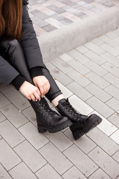 Piernas femeninas en botas de cuero negro primer plano Botas de mujer de otoño sin tacón