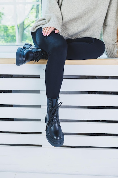 Piernas femeninas en botas de cuero negro primer plano Botas de mujer de otoño sin tacón