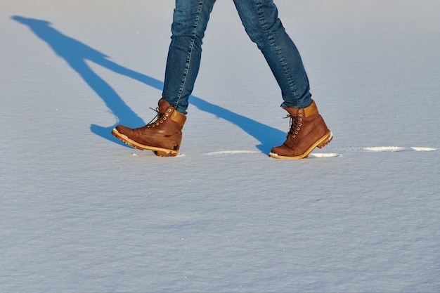 Una mujer aplica el spray a las botas de invierno nubuck marrón para mujer.  Cuidado repelente al agua de los zapatos, renovación y conservación del  color Fotografía de stock - Alamy